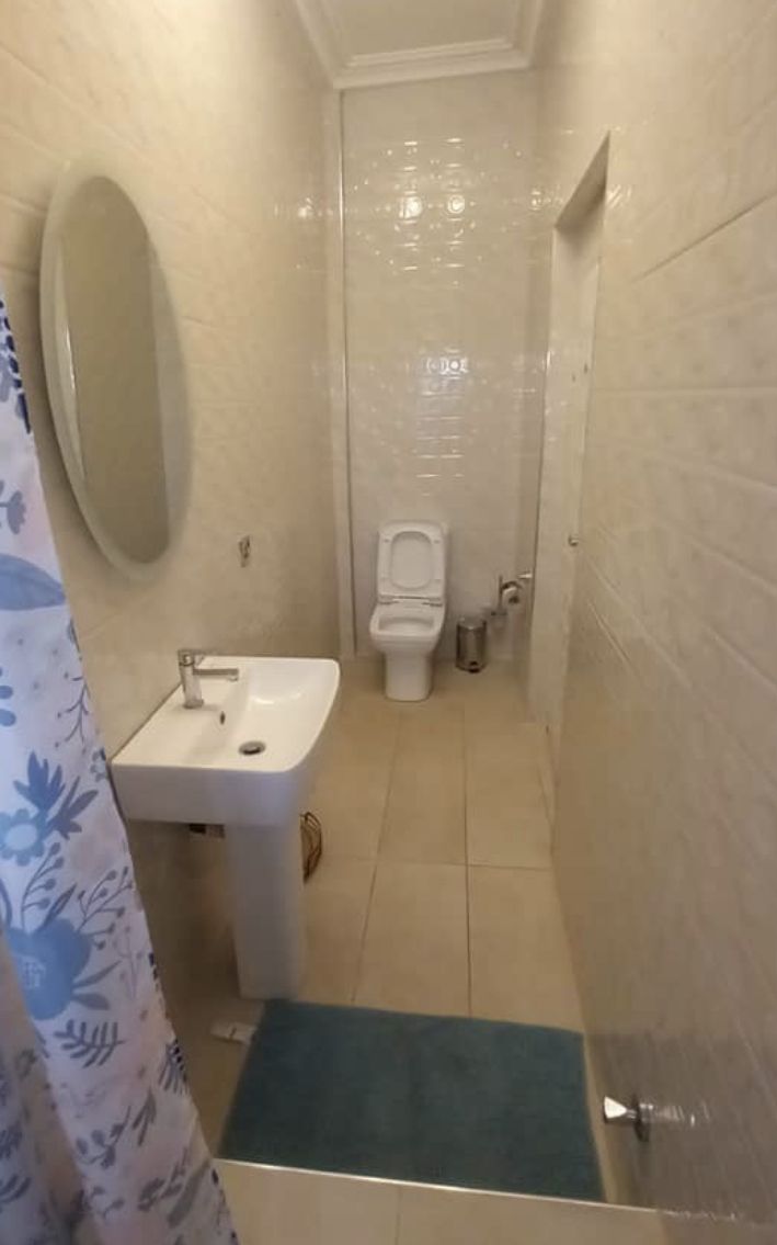 A bathroom with a sink, toilet, and shower area.