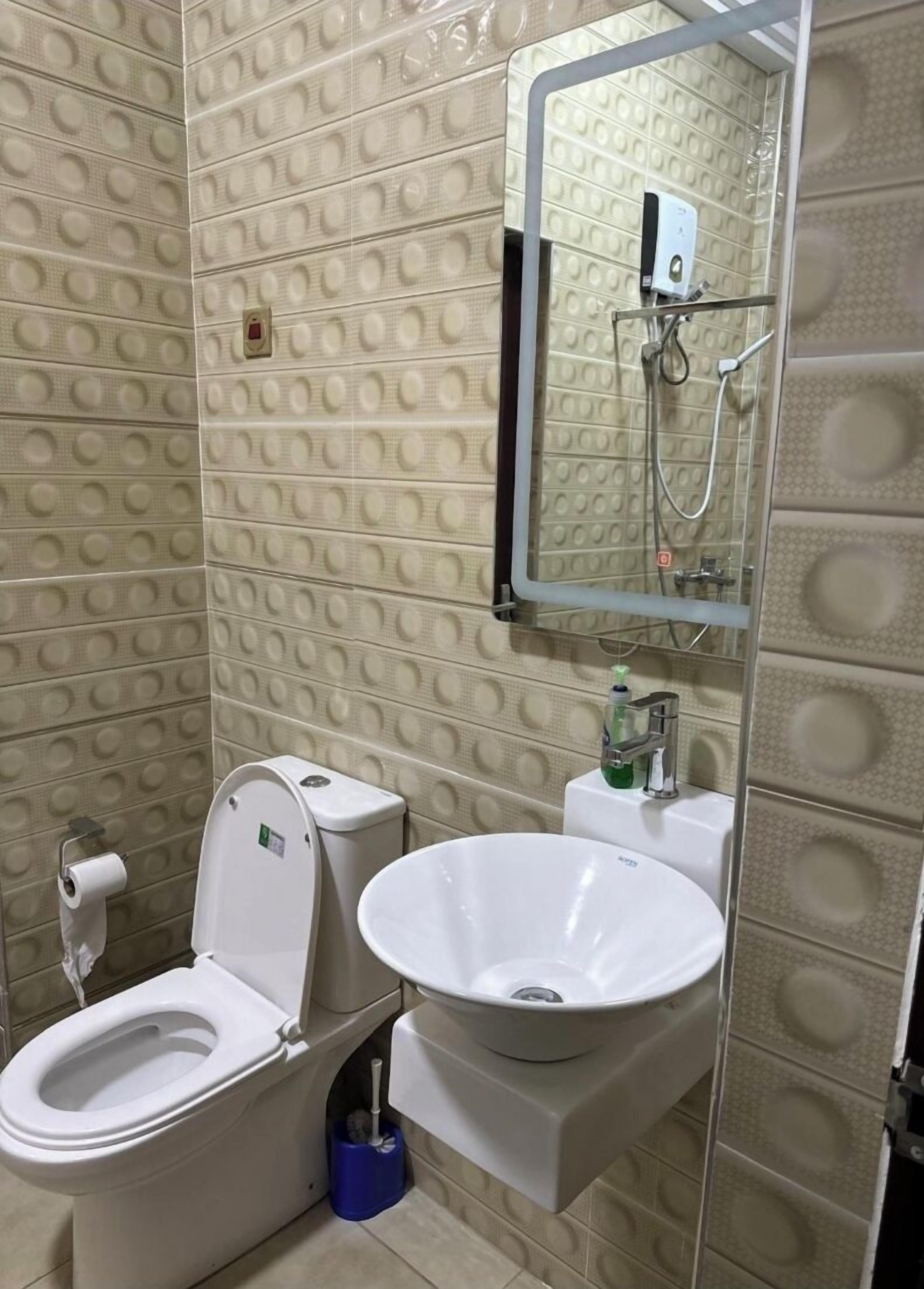A bathroom with a toilet, bidet, and sink.
