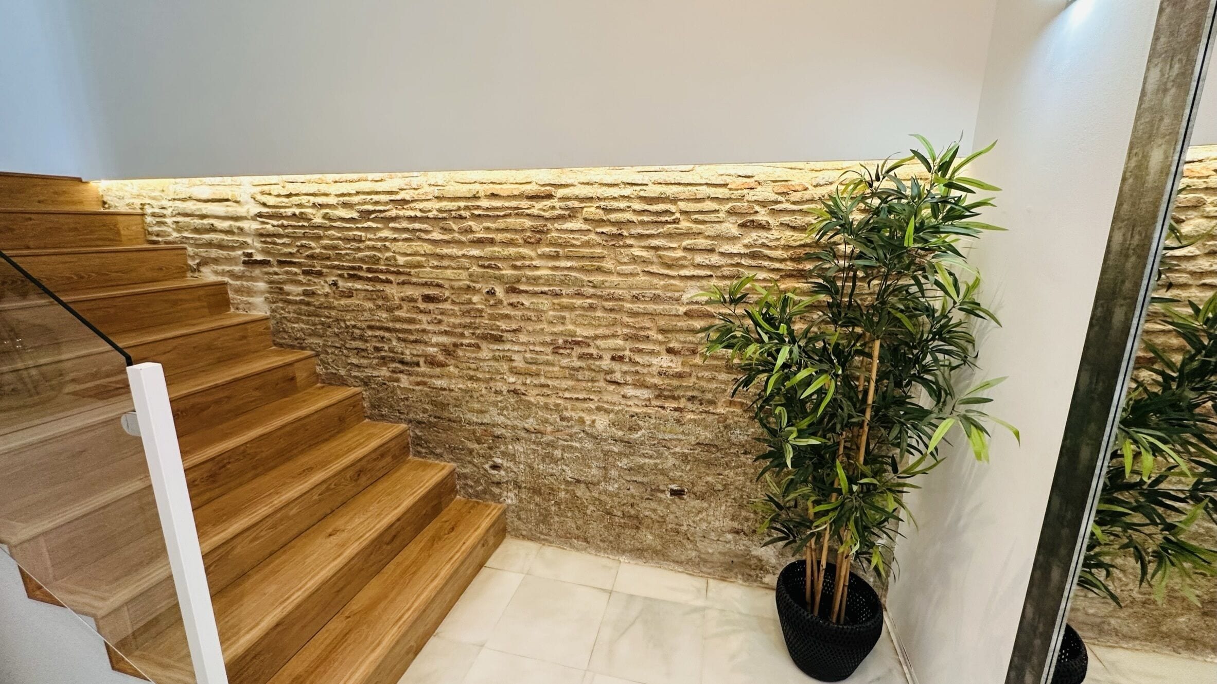 A staircase with wooden steps and a stone wall.