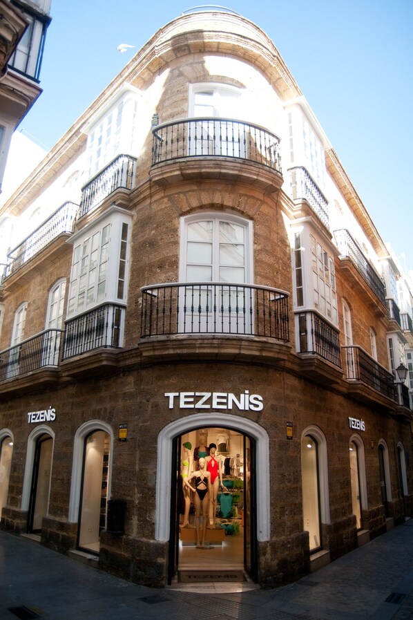 Un bâtiment d’angle dont la façade porte l’inscription « TEZENIS ».