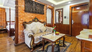 A room with a brick wall, a wooden sofa, a wooden table, and a mirror. - Amarawati Boutique Hotel (Kathmandu)