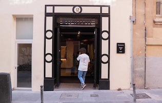 A hotel entrance with a numbered door, a sign indicating the location, and a visible window.