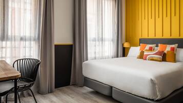 Una habitación de hotel con una cama, una mesa y una silla.