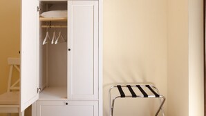 A white wardrobe with hanging space, a small stool, and a chair. - Court of Nobles (Conversano)