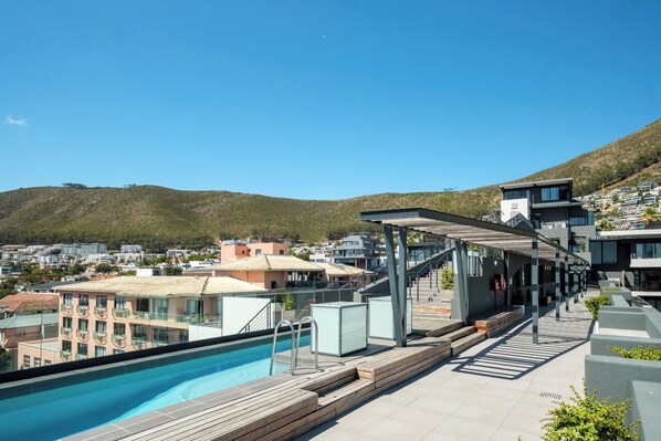 A rooftop pool area with a clear view of the surrounding buildings and hills.