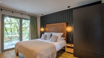 Quarto moderno com cama grande, cabeceira de madeira e porta deslizante para uma varanda.