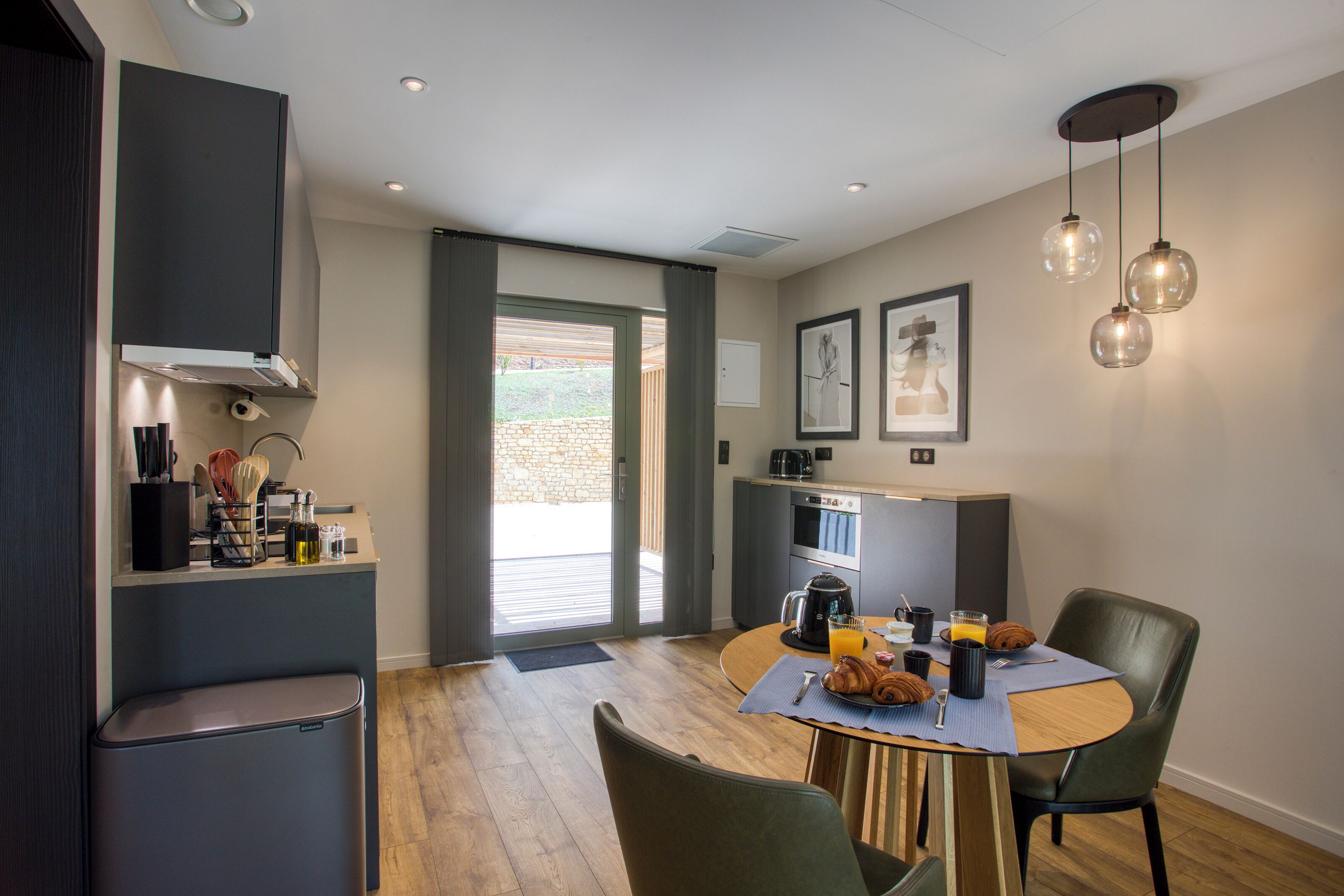 Una cocina moderna con comedor, que incluye una mesa redonda, sillas y una máquina de café.