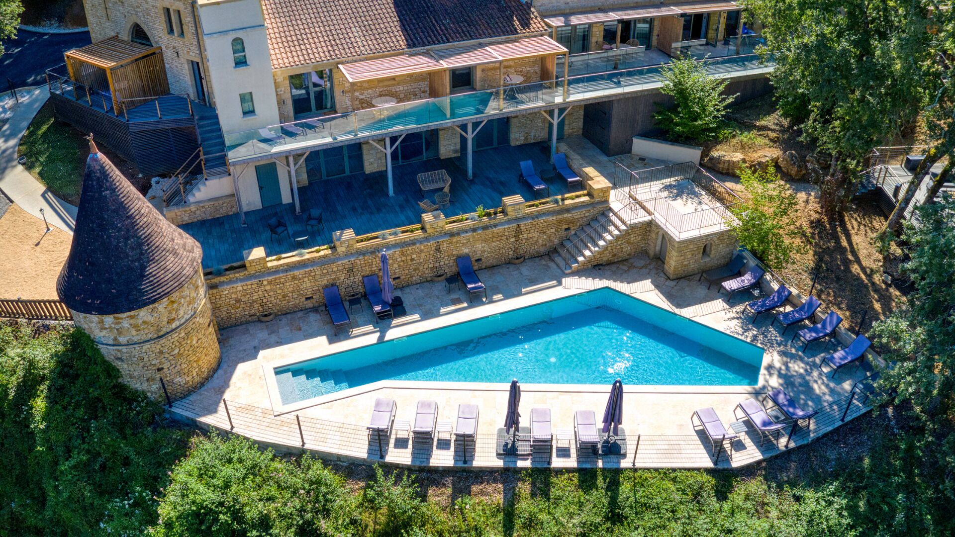 Una piscina al aire libre, sombrillas, tumbonas