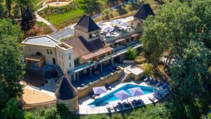 Un edificio grande de varios pisos con piscina y mobiliario exterior.