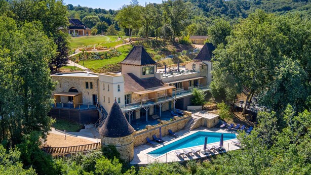 Una extensa propiedad con piscina, varias edificaciones y un jardín bien cuidado.