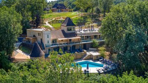 Una extensa propiedad con varias edificaciones, una piscina y un jardín bien cuidado.