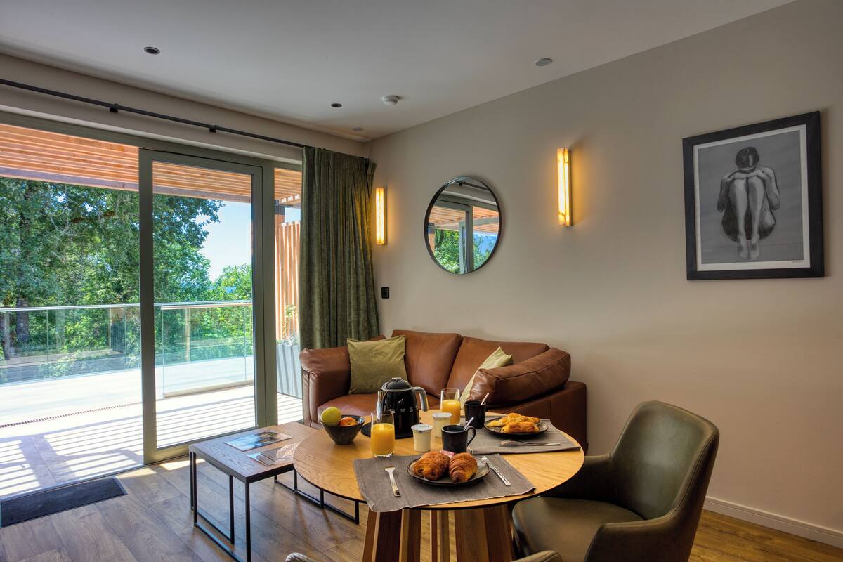 A modern living room with a sofa, a dining table, and breakfast items.