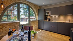 Una cocina moderna con paredes de piedra, ventanas amplias y electrodomésticos contemporáneos.