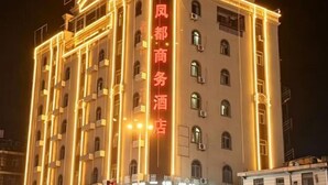Un edificio de varios pisos con letreros iluminados que indican que es un hotel.