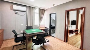 A room with a pool table, chairs, an air conditioning unit, a mirror, and a door leading to another room.