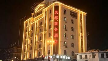 Een meerhoog hotel met verlichte signage en een opvallende ingang.