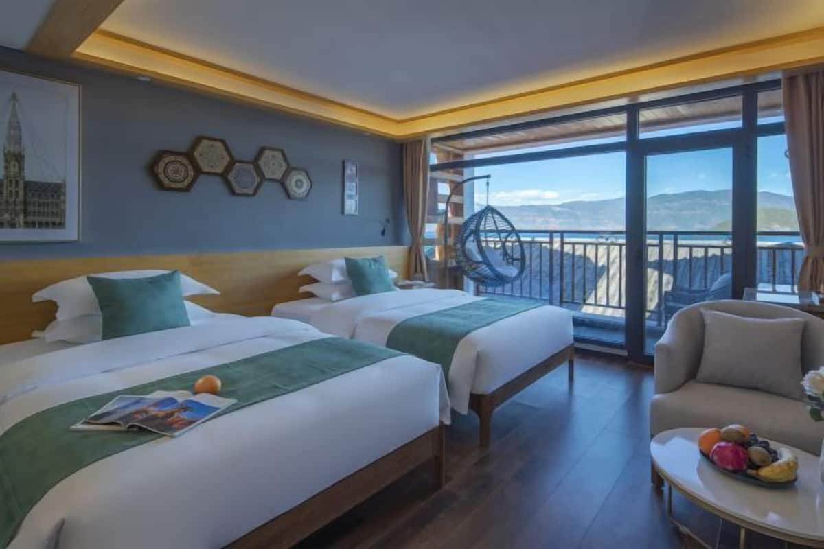 Relax in this stylish room with two single beds, a wooden headboard, and a large window offering a view of the mountains and sea.
