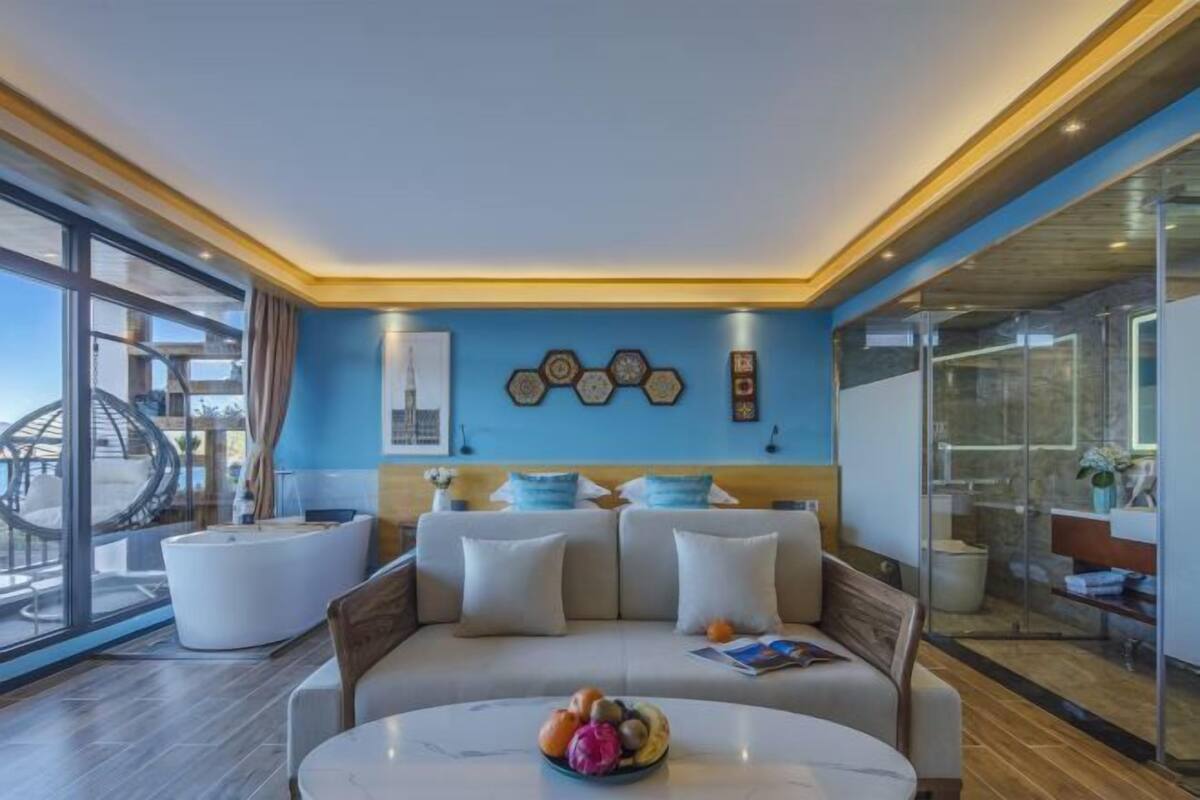 Relax in a spacious room with a sofa, coffee table, and large window offering a view of the outside.