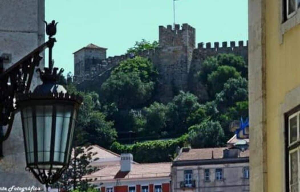 A view of a historic building with a prominent tower and a street lamp in the foreground.