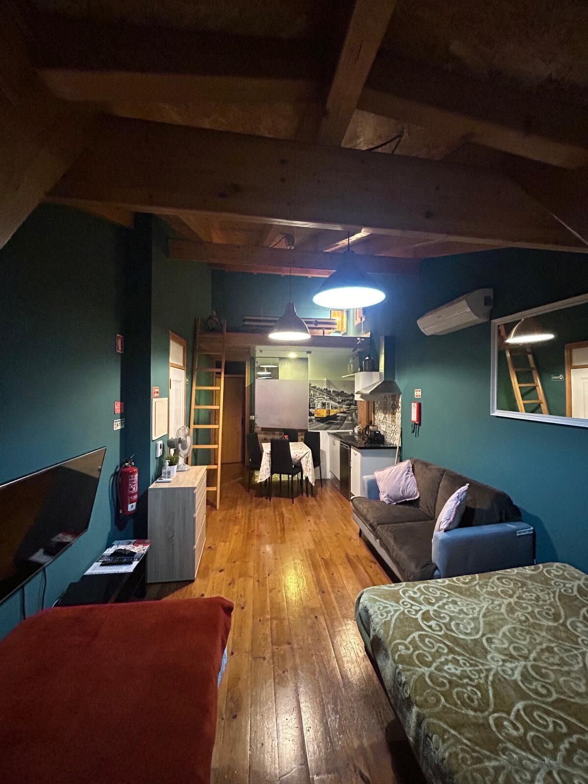 Una habitación compacta con kitchenette, comedor y zona de estar.