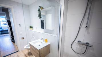 Kamer | Badkamer | Een douche, een haardroger, handdoeken, shampoo