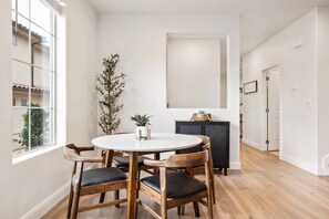 A dining area with a round table and wooden chairs, a potted plant, and a cabinet against the wall. - Red Rock Adventures: Pickleball, YouTube TV (Washington)