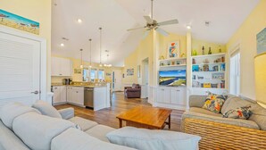 Un amplio espacio de estar con cocina, una mesa de comedor y un sofá.