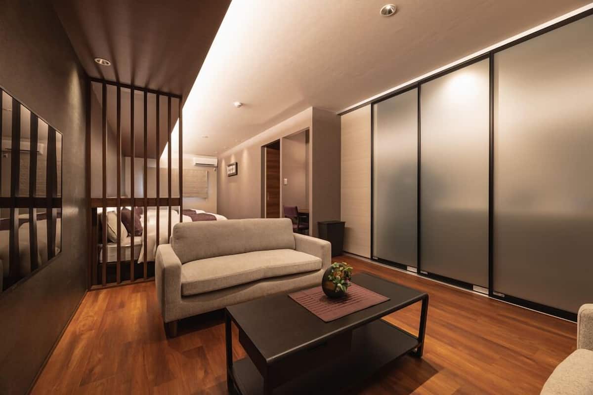 A modern living room with a sofa, a coffee table, and a sliding door with frosted glass panels.