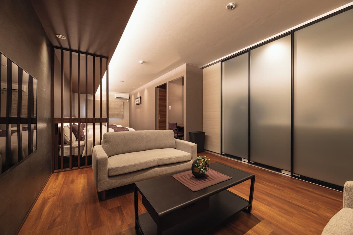 A modern living room with a sofa, a coffee table, and a sliding door.