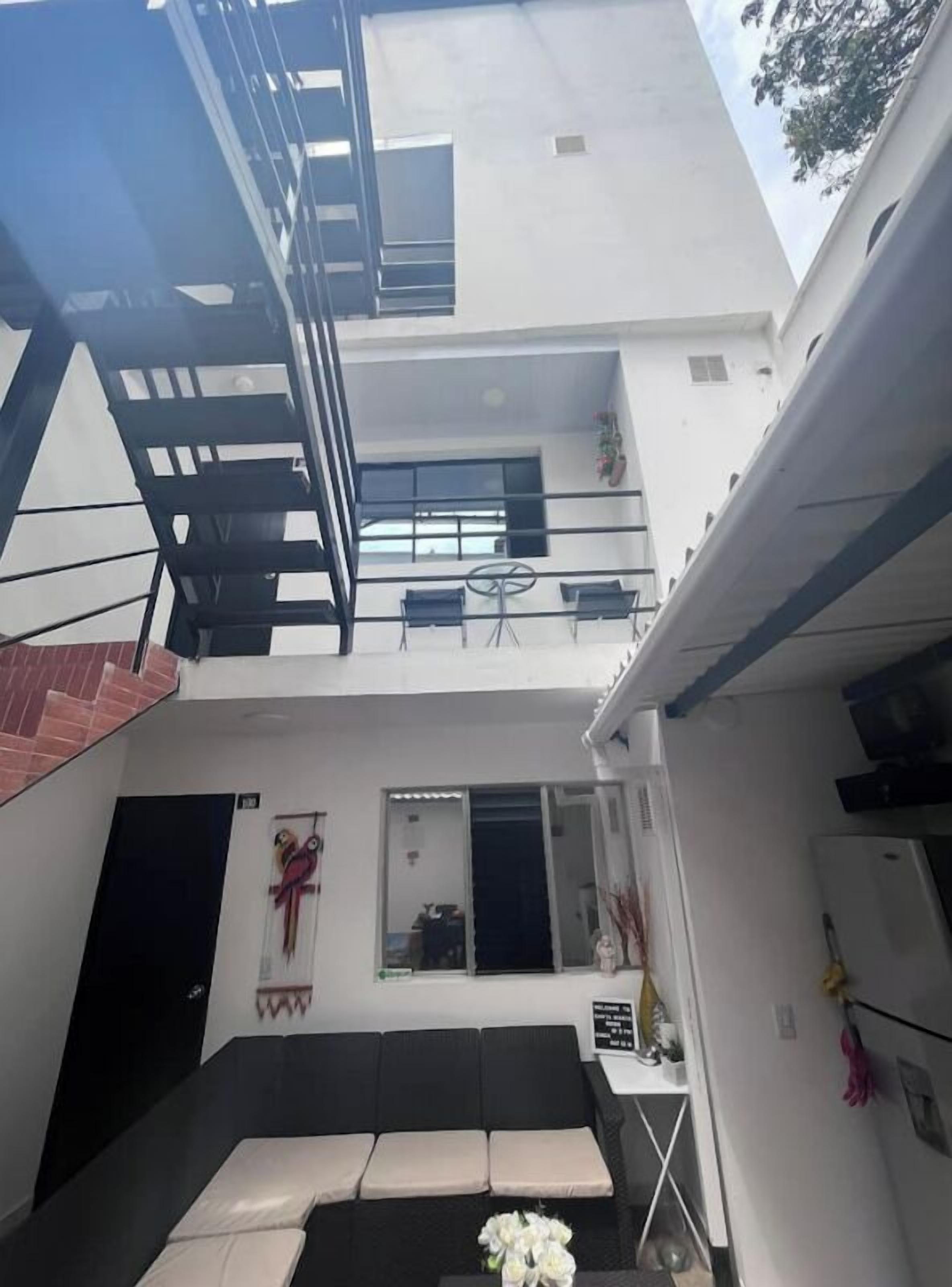 A modern building with a flat roof, a staircase, and a balcony.