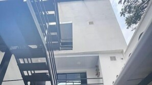 Un bâtiment moderne doté d’un toit plat, d’un escalier et d’un balcon.