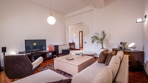 Un salon moderne avec un téléviseur à écran plat, une table basse, un canapé et une table à manger.