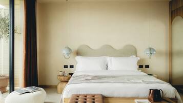 A neatly arranged bedroom with a bed, bedside lamps, a wooden nightstand, a reading bench, and a potted plant.