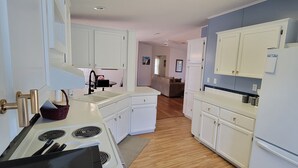 A kitchen with white cabinets, a stove, and a refrigerator.