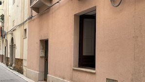 A building with a beige facade, a small window, and a door with a mailbox. - Fisherman's House (Trapani)