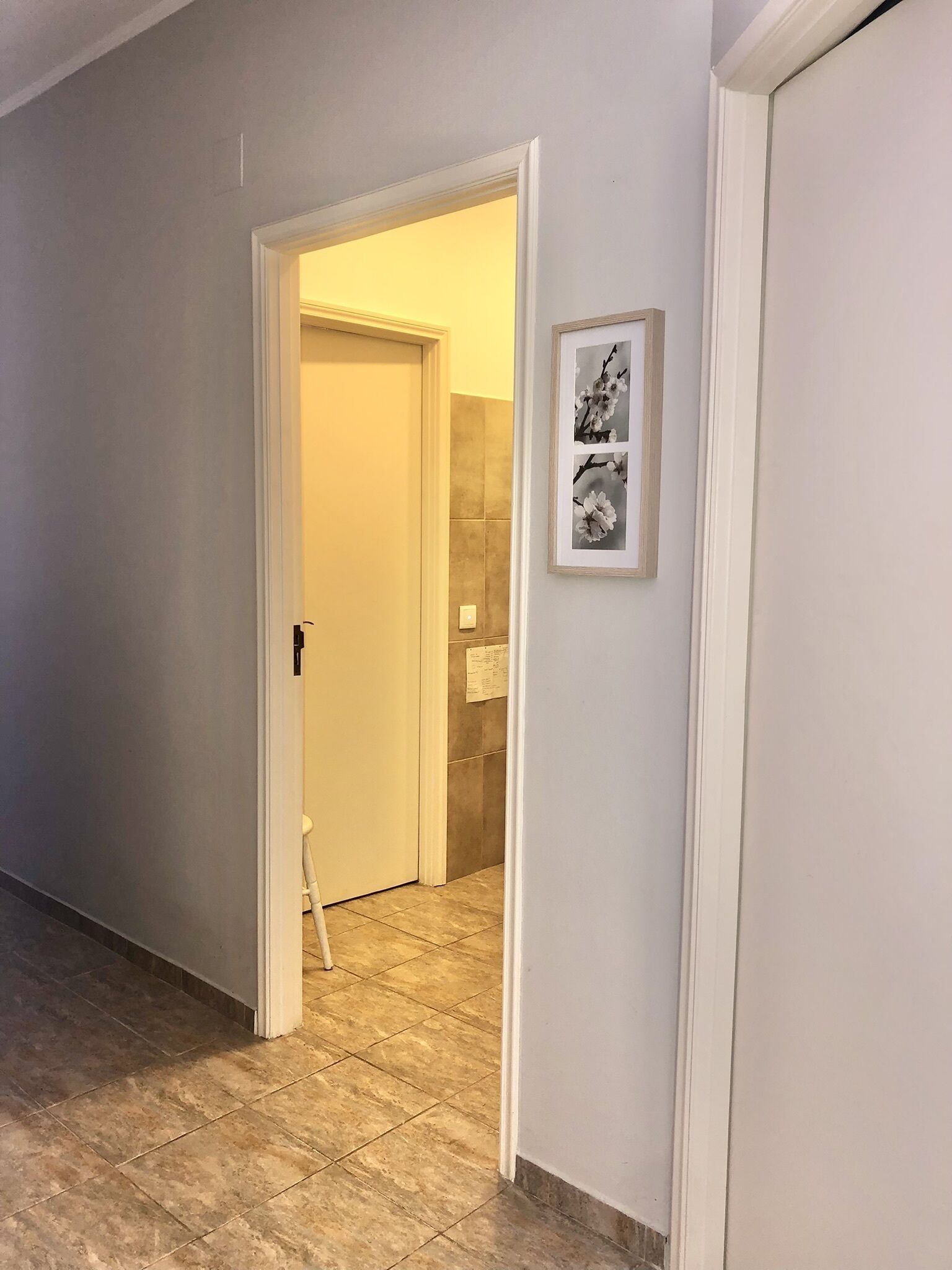 Un pasillo con una puerta que da a un baño.