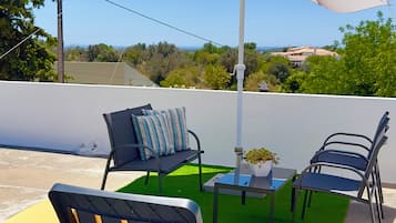 Relax in a serene outdoor space with a clear view of the surrounding landscape, featuring a shaded seating area with a table and two chairs.