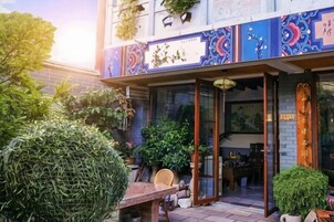 Un edificio de diseño tradicional, con un acceso de baldosas, una puerta de madera y un ventanal.