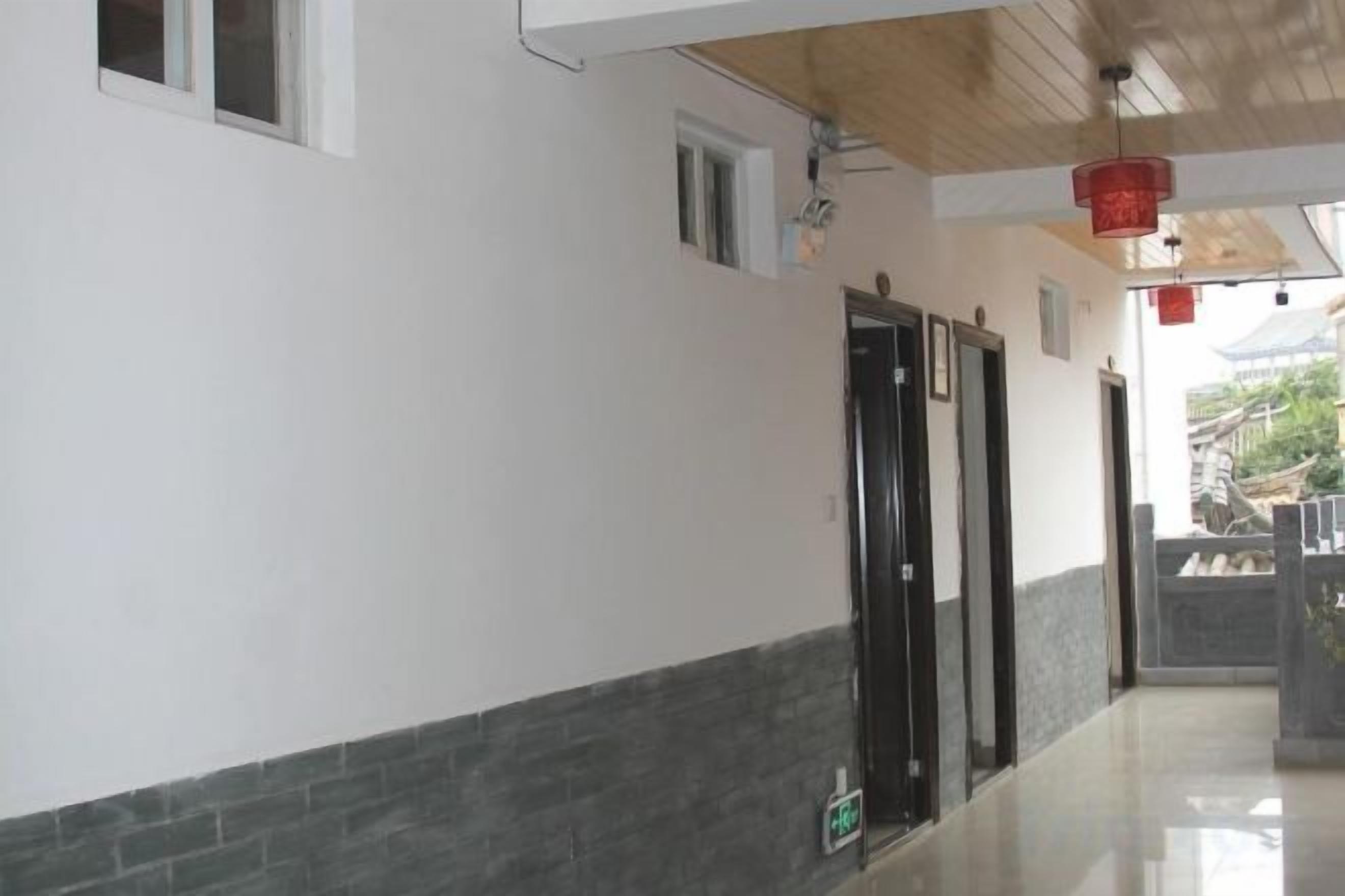 A hallway with a tiled floor, a door, and a window.