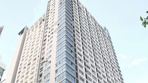A tall, modern high-rise building with a grid-like facade and numerous windows. - Xiamen Enfen Hotel (Xiamen)