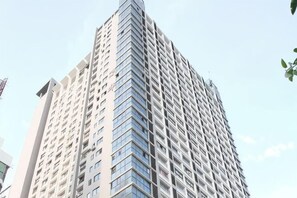 Ein hoher, moderner Wolkenkratzer mit einer gitterförmigen Fassade und zahlreichen Fenstern.