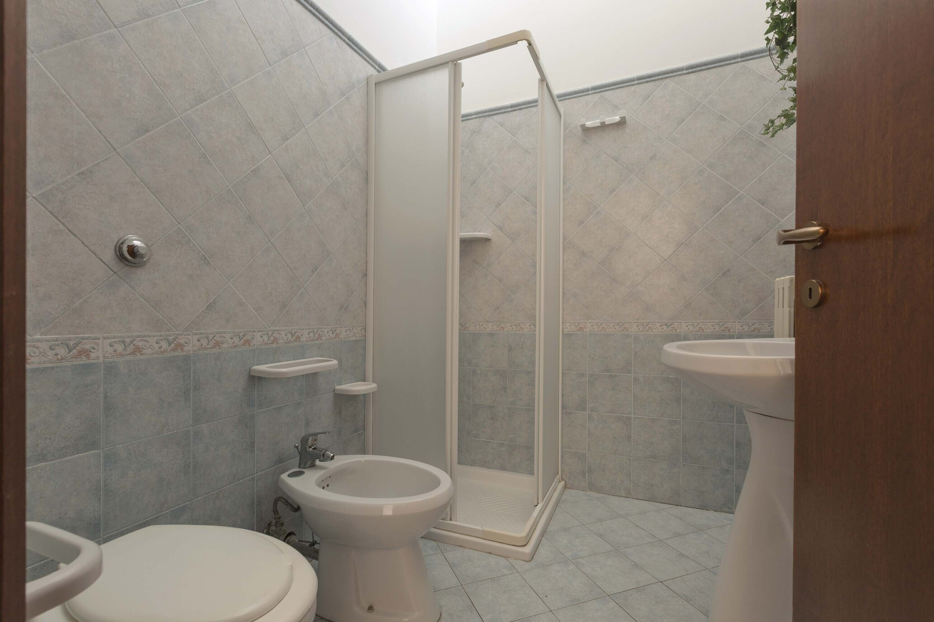 Un baño con ducha, inodoro, bidé y lavabo.