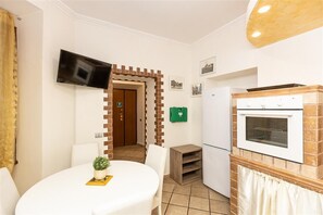 Une chambre d’hôtel comprenant un coin repas, un téléviseur fixé au mur, une cheminée en briques et un réfrigérateur.