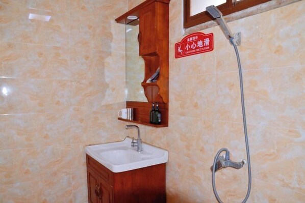 A bathroom with a sink, mirror, and shower. - Tiger Leaping Gorge Tea-Horse Guesthouse (Shangri-La)