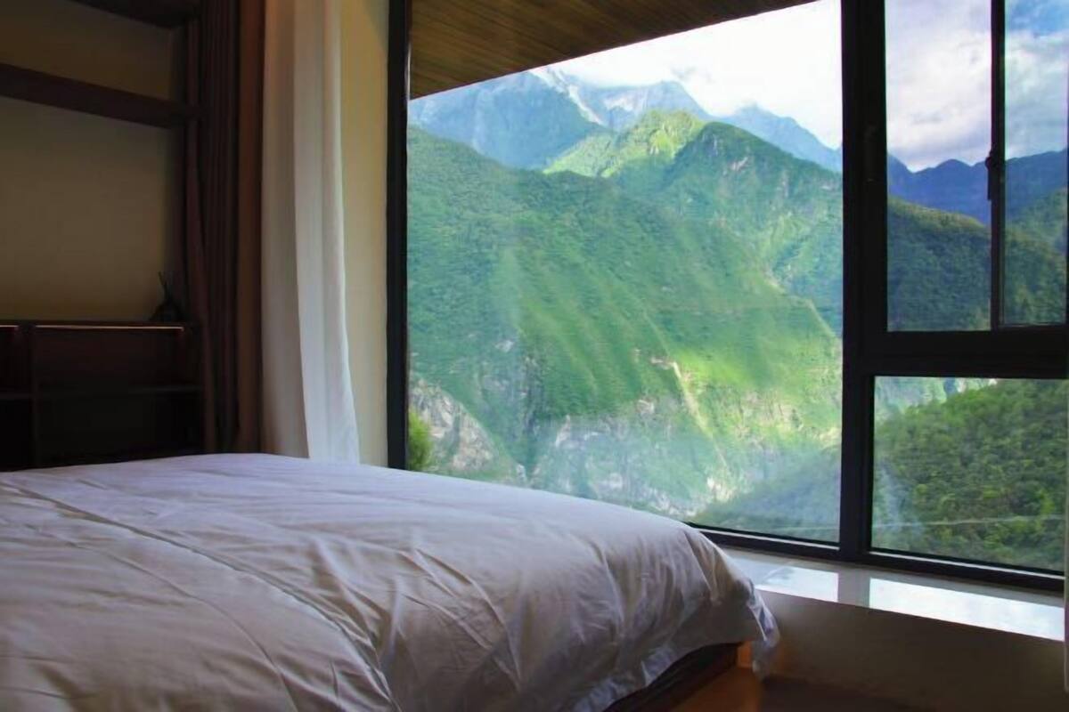 Un dormitorio con un ventanal que ofrece vistas a la montaña.