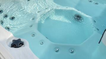 Ein Whirlpool mit klarem Wasser, Blasen und einem sternförmigen Abfluss.
