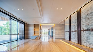 A modern hotel lobby with a wooden floor, glass doors, a reception desk, and a cityscape view. - Holiday Inn Zhuhai City Center (Zhuhai)