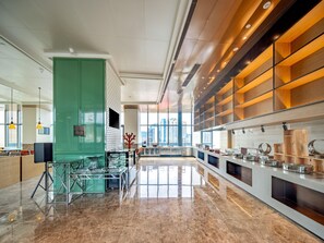 A modern kitchen with a central island, a green accent wall, and a city view. - Holiday Inn Zhuhai City Center (Zhuhai)