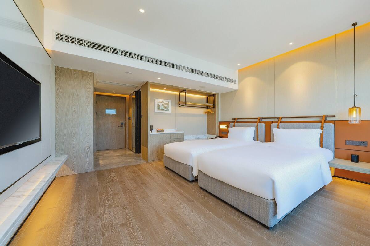 Une chambre d’hôtel avec un grand lit, une télévision, un bureau et une salle de bain.