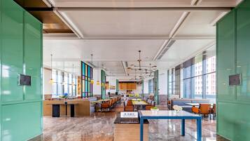 A spacious restaurant with high ceilings, large windows, and a modern interior design.